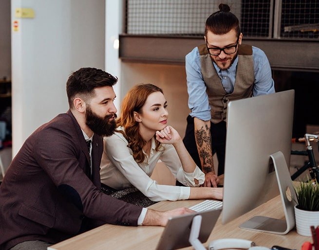 Team of coworkers collaborating in front of a large monitor